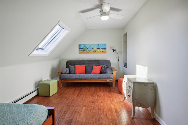 living area with baseboard heating, vaulted ceiling with skylight, ceiling fan, and hardwood / wood-style flooring