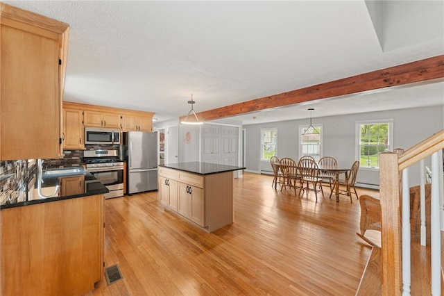 133 Old Pine Rd, Narragansett, RI 02882 - kitchen featuring appliances with stainless steel finishes, dark countertops, light wood-style flooring, a center island, and beamed ceiling