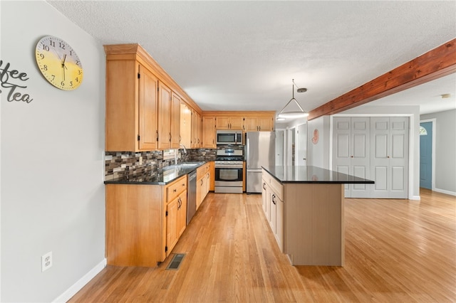 133 Old Pine Rd, Narragansett, RI 02882 - kitchen featuring stainless steel appliances, a sink, dark countertops, light wood-style flooring, and a textured ceiling