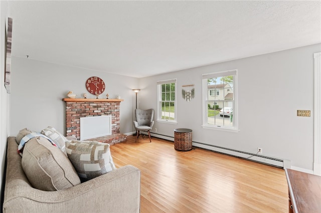 133 Old Pine Rd, Narragansett, RI 02882 - living room with a baseboard heating unit, wood finished floors, and a brick fireplace