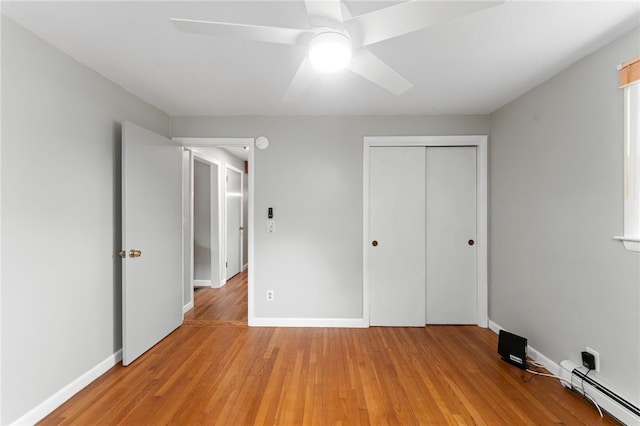 133 Old Pine Rd, Narragansett, RI 02882 - unfurnished bedroom with a baseboard heating unit, a closet, light wood-type flooring, and baseboards