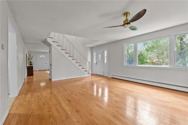 entrance foyer featuring baseboards, a ceiling fan, stairway, light wood finished floors, and a baseboard heating unit