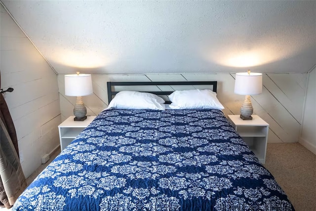 carpeted bedroom featuring a textured ceiling and lofted ceiling