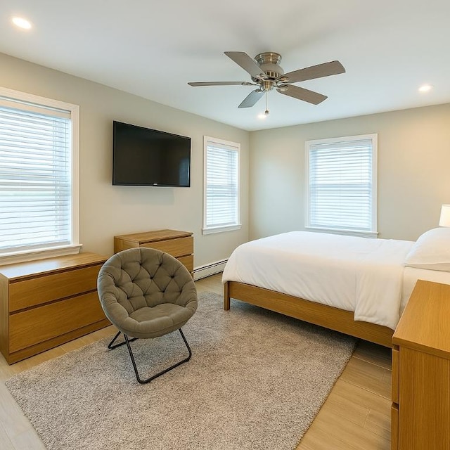 bedroom with a baseboard radiator, recessed lighting, a ceiling fan, and light wood-type flooring