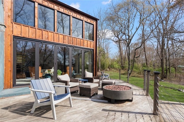 deck featuring an outdoor living space with a fire pit