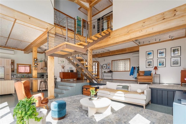 living area with stairway, a wall mounted AC, and a towering ceiling