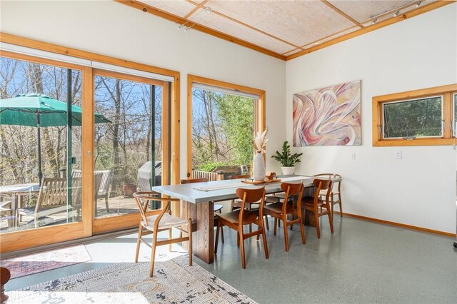 dining room featuring speckled floor and baseboards