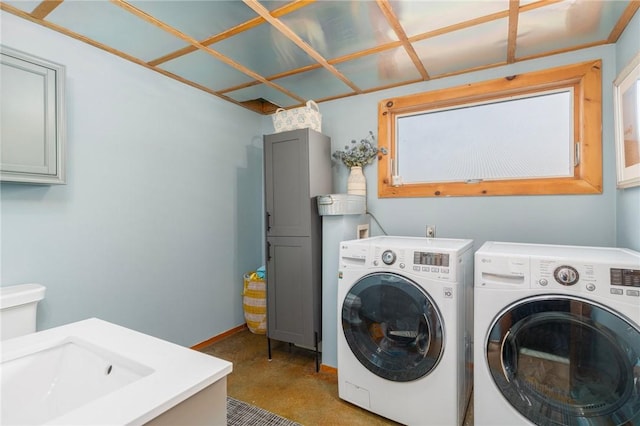 clothes washing area featuring washer and dryer, laundry area, and a sink