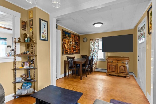 77 Seamans St, Providence, RI 02908 - living area featuring baseboards, baseboard heating, light wood-type flooring, and ornamental molding