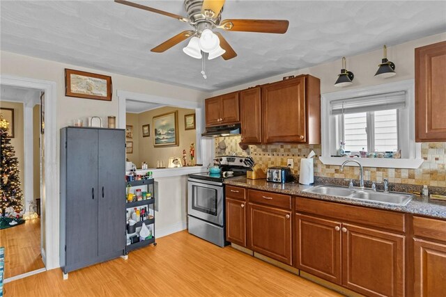 77 Seamans St, Providence, RI 02908 - kitchen with a ceiling fan, under cabinet range hood, brown cabinetry, stainless steel range with electric cooktop, and a sink
