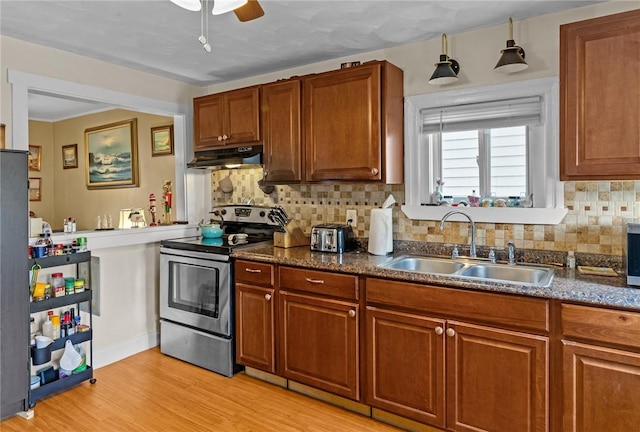 77 Seamans St, Providence, RI 02908 - kitchen with stainless steel range with electric stovetop, a sink, a ceiling fan, under cabinet range hood, and brown cabinetry