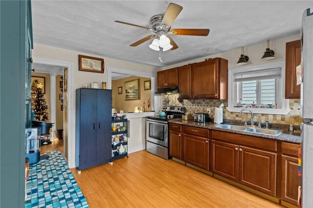 77 Seamans St, Providence, RI 02908 - kitchen with stainless steel electric range, a ceiling fan, under cabinet range hood, light wood-style floors, and a sink