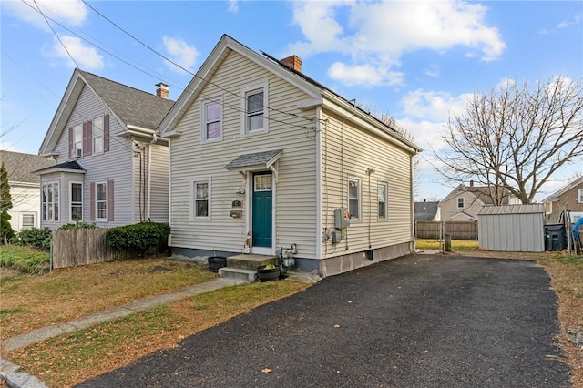 77 Seamans St, Providence, RI 02908 - traditional-style home featuring a chimney, aphalt driveway, and fence