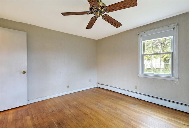 spare room featuring wood-type flooring, ceiling fan, and baseboard heating
