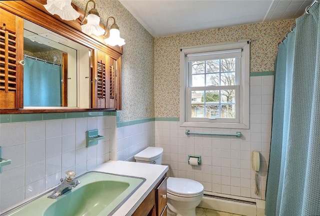 bathroom with toilet, tile walls, wainscoting, wallpapered walls, and a baseboard heating unit