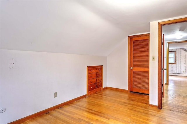 additional living space with baseboards, light wood finished floors, and a baseboard radiator