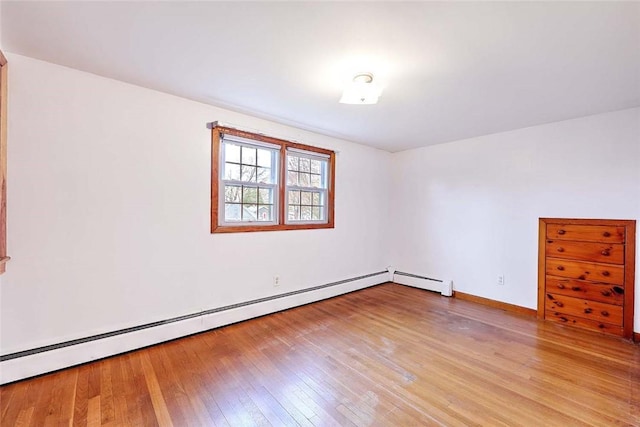 spare room with baseboards, light wood-type flooring, and baseboard heating