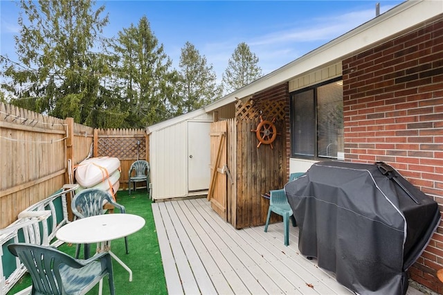 deck with area for grilling and a fenced backyard