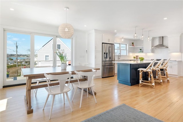 dining space with recessed lighting and light wood-style flooring