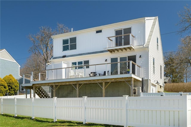 rear view of property with a balcony and fence