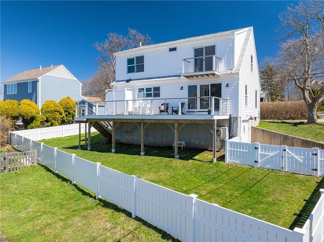 rear view of property featuring a gate, stairs, a fenced backyard, a lawn, and a deck