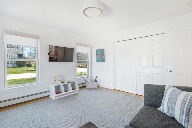 living room with baseboard heating and wood finished floors