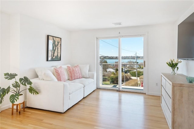 living area featuring light wood-style flooring and baseboards