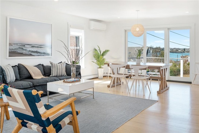 living room with light wood-style flooring, a wall mounted AC, recessed lighting, and baseboard heating