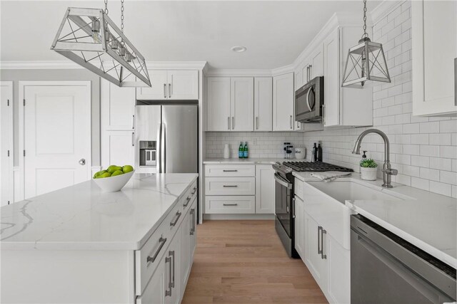 0 Greenwich Blvd Unit 110, East Greenwich, RI 02818 - kitchen with stainless steel appliances, tasteful backsplash, white cabinets, a center island, and ornamental molding