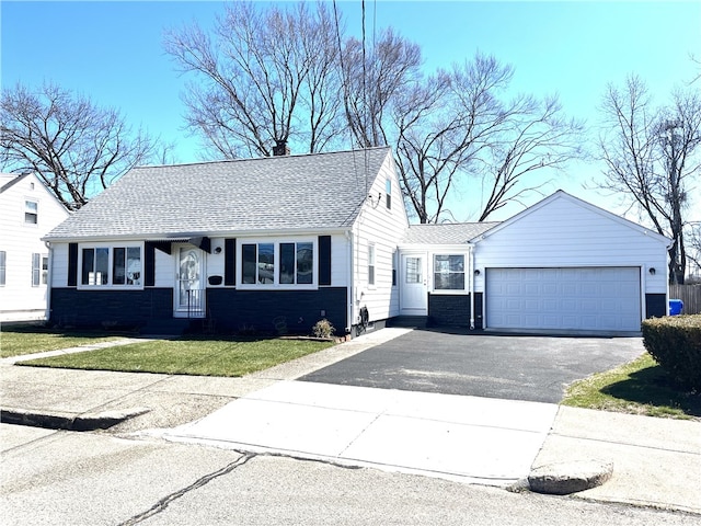 view of front of property with a chimney, an attached garage, a front lawn, aphalt driveway, and a shingled roof