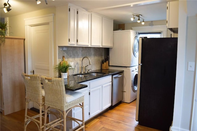 33 Almy St, Newport, RI 02840 - kitchen with appliances with stainless steel finishes, stacked washer and clothes dryer, a sink, and white cabinets