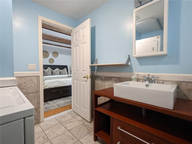 33 Almy St, Newport, RI 02840 - ensuite bathroom featuring vanity, ensuite bath, marble finish floor, wainscoting, and tile walls