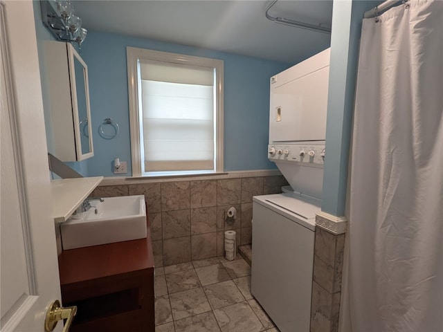 33 Almy St, Newport, RI 02840 - bathroom featuring tile walls, vanity, a wainscoted wall, and stacked washer / drying machine