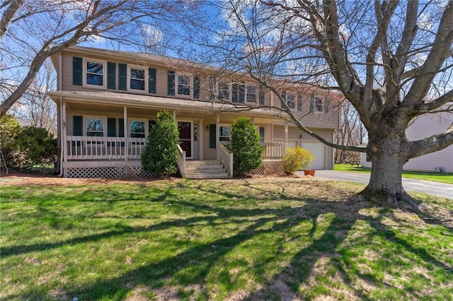 view of front of home featuring a front lawn, an attached garage, covered porch, and driveway