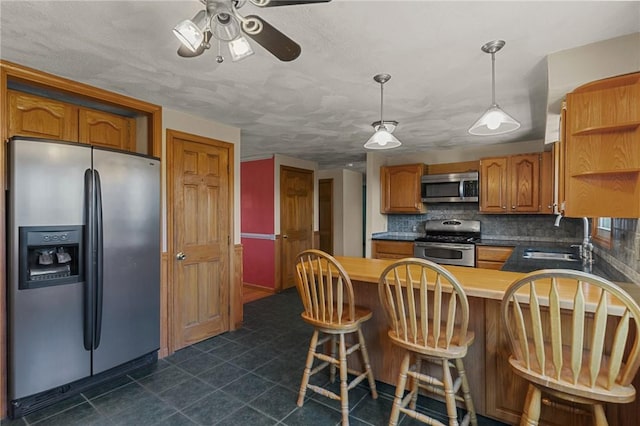 kitchen with open shelves, a sink, a ceiling fan, a peninsula, and stainless steel appliances
