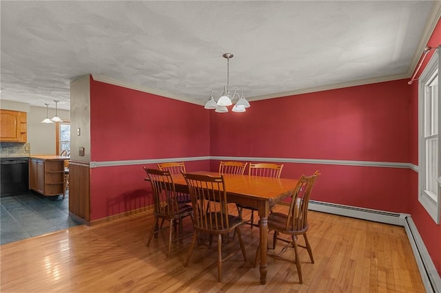 dining space featuring a chandelier, wood finished floors, and baseboard heating