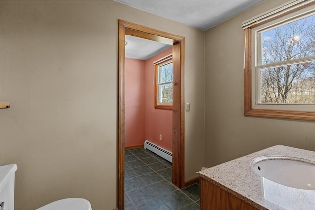 bathroom with vanity, a baseboard heating unit, baseboards, tile patterned flooring, and toilet