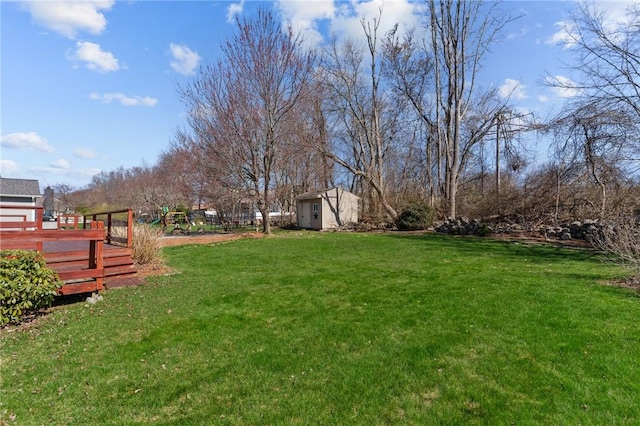 view of yard featuring a shed, a deck, and an outdoor structure
