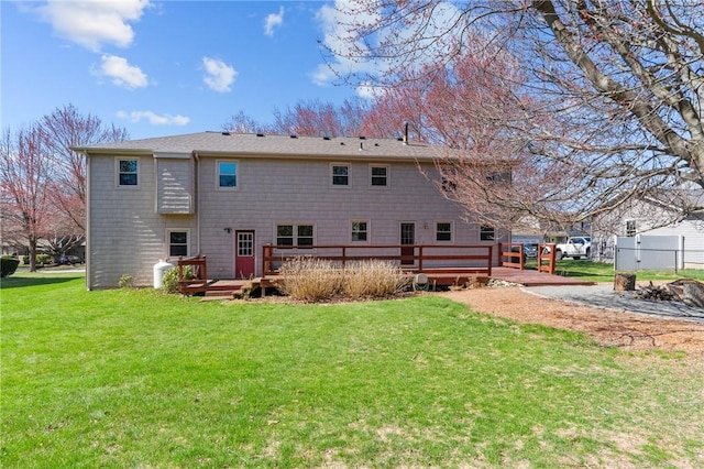 rear view of property with a deck and a lawn