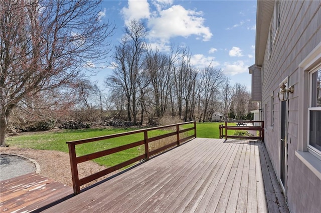 wooden deck featuring a lawn
