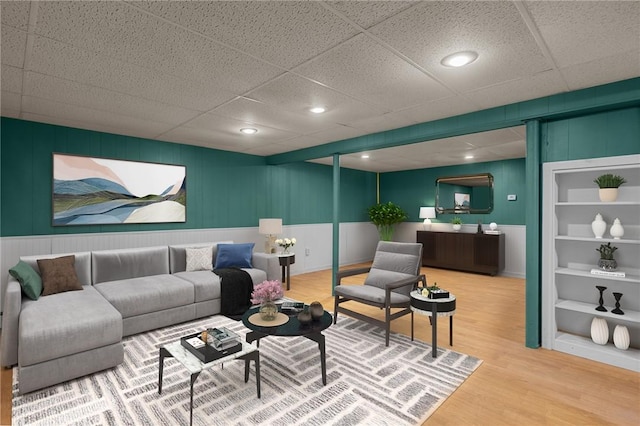 living area with a decorative wall, recessed lighting, and wood finished floors