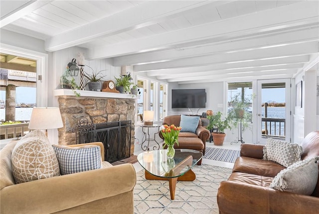 1597 Main Rd, Tiverton, RI 02878 - living room with beamed ceiling, french doors, and a stone fireplace