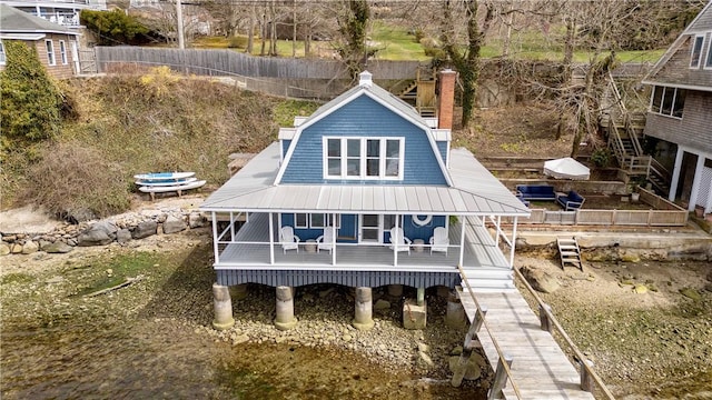 1597 Main Rd, Tiverton, RI 02878 - back of property with a chimney, covered porch, fence, metal roof, and stairs