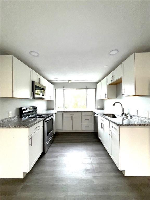 53 Urban Ave Unit 6, North Providence, RI 02904 - kitchen with a sink, white cabinetry, dark wood-style flooring, and stainless steel appliances