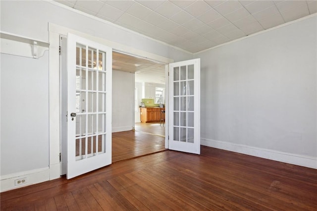 spare room with baseboards, crown molding, french doors, and hardwood / wood-style floors