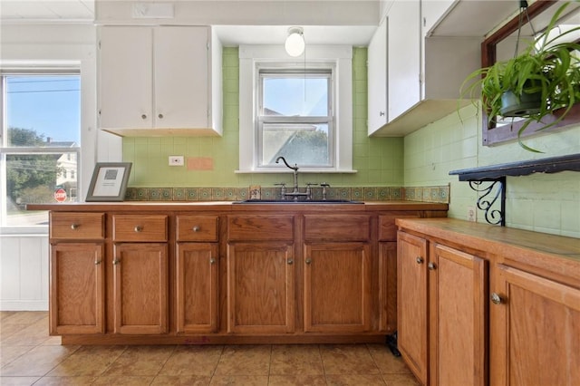 kitchen featuring a sink, brown cabinets, and light tile patterned floors
