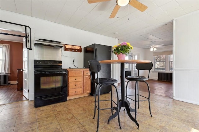 kitchen featuring radiator, exhaust hood, ceiling fan, and black appliances