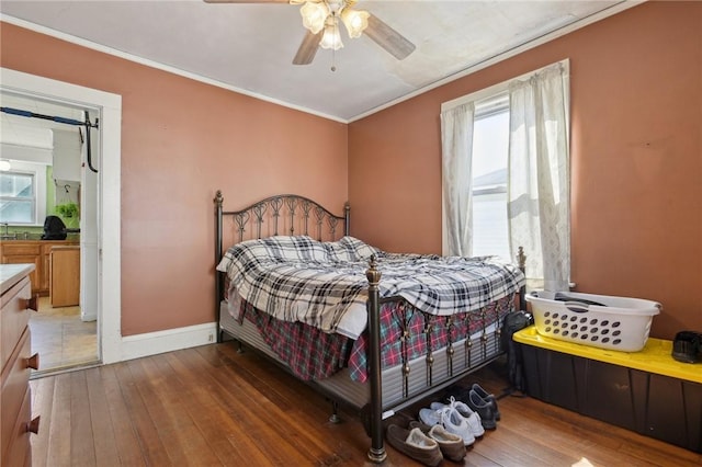 bedroom featuring crown molding, hardwood / wood-style flooring, and multiple windows
