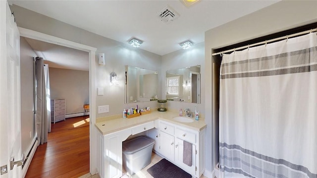 full bathroom with vanity, visible vents, baseboard heating, wood finished floors, and a baseboard radiator