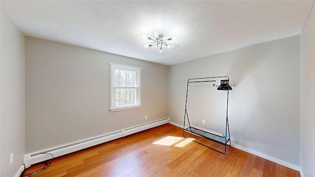 empty room with light wood-style flooring, baseboards, and baseboard heating